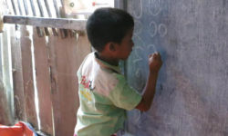Boy writing Marma on blackboard