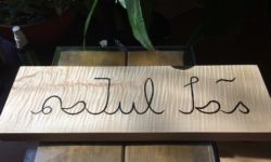 "Mother tongue" in Hanifi Rohingya. Carving and photo by Tim Brookes. Hanifi Rohingya Carving