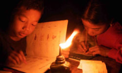 Mru children studying at night; Pora Para, Bandarban. 2005. Working on Mru by candlelight