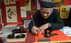 A calligrapher writes down best wishes for the lunar new year or Tet in Vietnamese, for customers outside the Temple of Literature in downtown Hanoi on February 8, 2013. Photo credit: Yahoo News A calligrapher writes down best wishes for the lunar new year or Tet in Vietnamese, for customers outside the Temple of Literature in downtown Hanoi