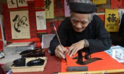 A calligrapher writes down best wishes for the lunar new year or Tet in Vietnamese, for customers outside the Temple of Literature in downtown Hanoi on February 8, 2013. Photo credit: Yahoo News A calligrapher writes down best wishes for the lunar new year or Tet in Vietnamese, for customers outside the Temple of Literature in downtown Hanoi