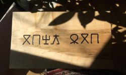 "Save our language" in Zaghawa using the Beria script. Carving and photo by Tim Brookes. Beria carving