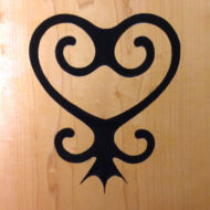 Sankofa. Originally a bird looking back over its own shoulder, the Sakofa symbol means "Return and get it," or "Learn from the past." Carving and photo by Tim Brookes. Sankofa Carving