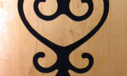 Sankofa. Originally a bird looking back over its own shoulder, the Sakofa symbol means "Return and get it," or "Learn from the past." Carving and photo by Tim Brookes. Sankofa Carving